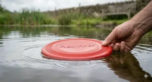 A waterproof, flexible rubber dog frisbee floating on a pond during a walk.