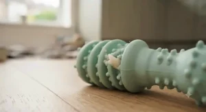 Illustration demonstrating how bristles and ridges on a chew toy help scrape plaque from a puppy's teeth.